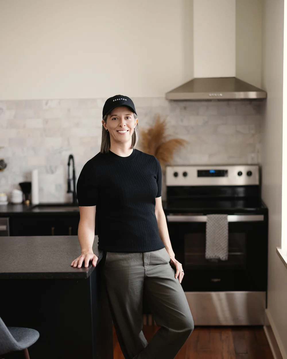 Tasha Francis leaning on a kitchen counter in a bright loft