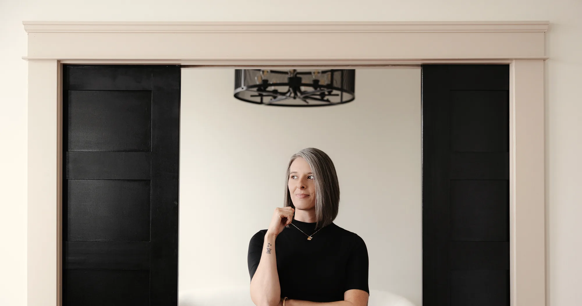 Tasha Francis standing between black double doors in a bright Knoxville home